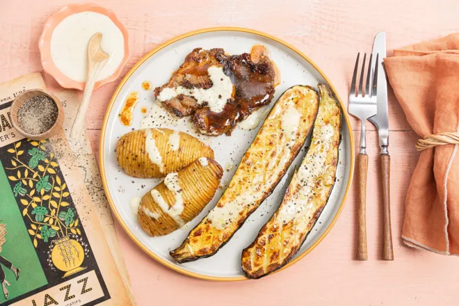 Côte de porc marinée, sauce Alabama, courgettes et pommes de terre Hasselback rôties